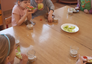 Przy stole siedzą 4 dziewczynki jedzą samodzielnie zrobione kanapki