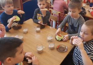 Przy stole siedzi 5 chłopców jedzą kanapki które sami przygotowali