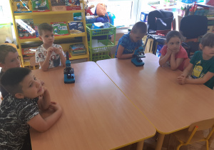 Przy stole od lewej str siedzi 4 chłopców, oraz 2 dziewczynki, na stole stoja 2 mikroskopy