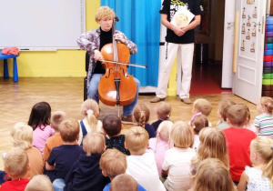 Dzieci oglądają występ Pana Witka i jego gościa grającego na wiolonczeli