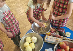 Dzieci trą jabłko na tarce