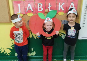 Dzieci z fotobudką w kształcie jabłka pozują do zdjęcia