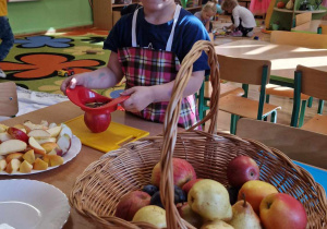 Chłopiec kroi jabłko na deseczce