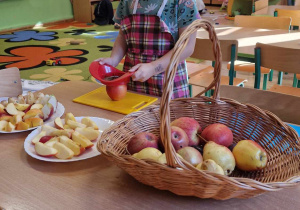 Dziewczynka kroi jabłko na deseczce