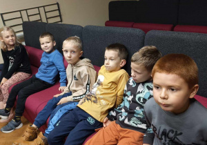Dzieci siedzą w sali filmowej.