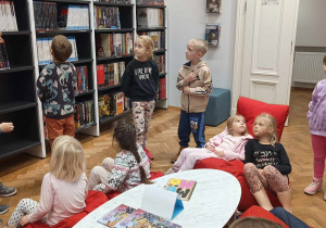Dzieci oglądają salę biblioteczną.