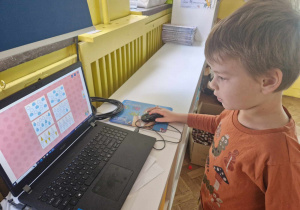 Chłopiec koloruje kropelki wykorzystując komputer