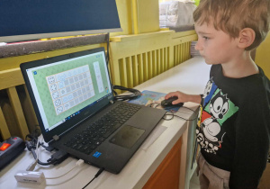 Chłopiec dopasowuje elementy w grze na komputerze