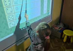 Dziewczynka przelicza kropelki na tablicy interaktywnej