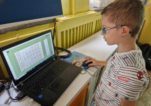Chłopiec dopasowuje elementy w grze na komputerze