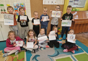 Dzieci prezentują swoje laptopy zrobione z papieru