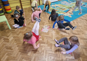 Dzieci kręcą się na gazecie w pozycji siedzącej