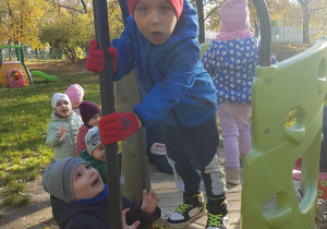 Chłopiec bawi się wykorzystując sprzety w ogrodzie przedszkolnym.