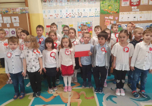 Dzieci trzymają flagę Polski i śpiewają hymn