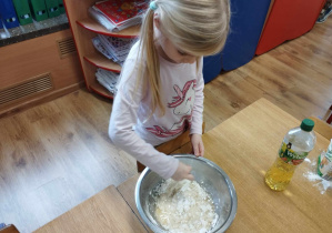Dziewczynka miesza składniki w misce.
