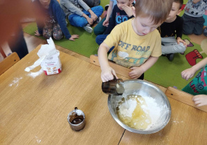Chłopiec wlewa olej do miski