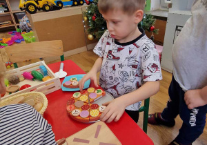 Chłopciec bawi się drewnianymi zabawkami od Św. Mikołaja