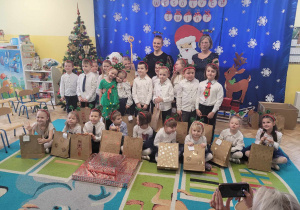 Zdjęcie dzieci z grupy 4 z Świętym Mikołajem i nauczycielkami.