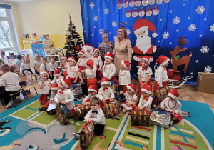 Zdjęcie dzieci z grupy 1 z Świętym Mikołajem, nauczycielką i pomocą nauczyciela.
