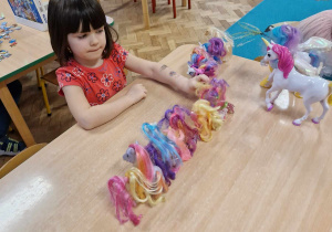 dziewczynka bawi się kucykami pony