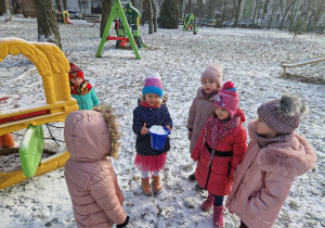 Dzieci obserwują lód zamarznięty w wiaderku
