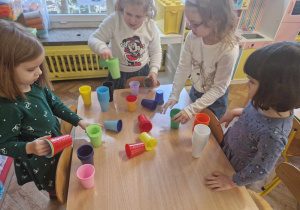 Dzieci segregują kolorowe kubeczki w/g koloru
