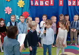 Dzieci recytują wiersze przez mikrofon.