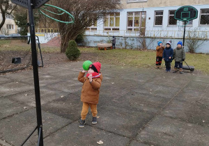 Chłopiec rzuca piłkę do kosza.