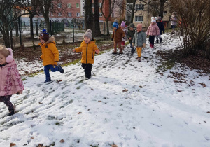 Dzieci uczestniczą w zabawach na śniegu.