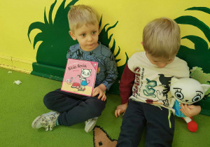 Chłopcy trzymają książkę,,Kicia Kocia " oraz maskotkę Kici Koci