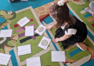 Dziewczynka gra na dywanie w memory
