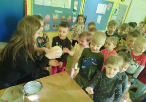 Dzieci uczestniczą w eksperymencie z suchym lodem i balonem.