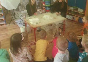 Dzieci oglądają eksperymenty z suchym lodem.