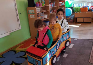 3 dzieci w modelu autobusu miejskiego.