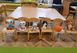 Kocie maskotki siedzą na krzesełkach