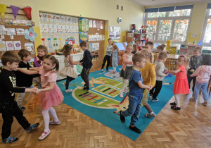 Dzieci tańczą do muzyki z użyciem kolorowych chusteczek
