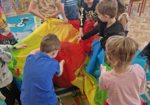 Dzieci odkrywają kto ukrył się w kolorowej chuście