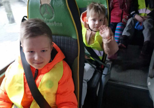 Dzieci zapięte w pasy siedzą w busie