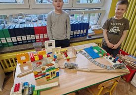 Dzieci budują swoją makietę z wykorzystaniem modeli autobusu i tramwaju
