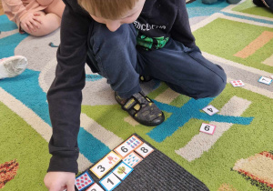 Chłopiec układa domino liczbowe