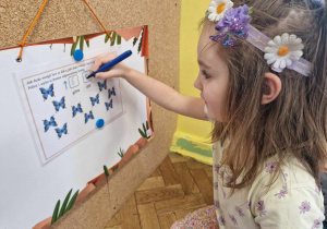 Dziewczynka wpisuje liczbę motyli frunących w dół