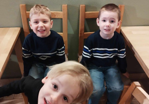 Trzej chłopcy siedzą przy stolikach w baśniowej kawiarence.