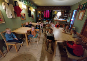 Dzieci siedzą przy stolikach w baśniowej kawiarence.