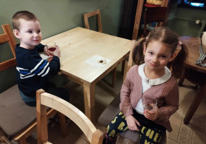 Chłopiec i dziewczynka piją sok w baśniowej kawiarence.