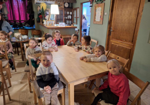 Dzieci siedzą przy stolikach w baśniowej kawiarence.