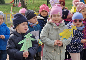 Dzieci trzymają w ręku sylwetę marzanny którą zrobiły samodzielnie