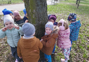 Dzieci stoją wkoło drzewa